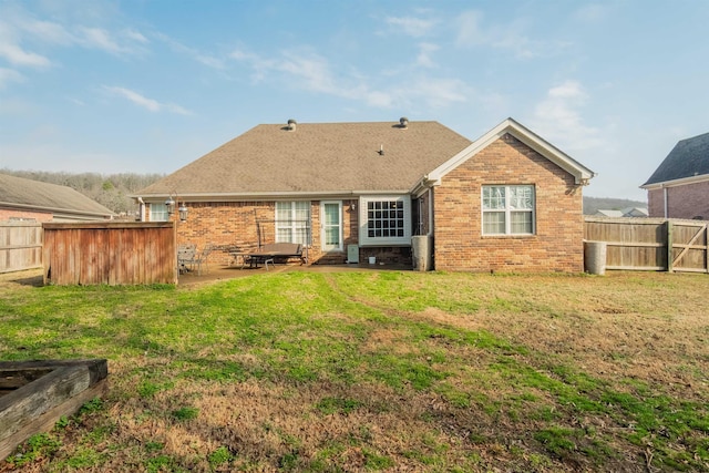 rear view of property with a yard and a patio area