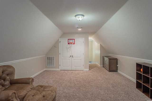 bonus room with light colored carpet, lofted ceiling, and a textured ceiling