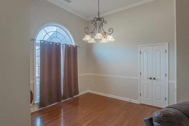 interior space with ornamental molding, dark hardwood / wood-style flooring, and a chandelier