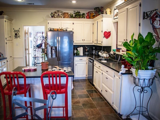 kitchen featuring sink, white cabinetry, crown molding, appliances with stainless steel finishes, and backsplash