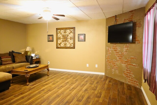 living room with hardwood / wood-style floors, a paneled ceiling, and ceiling fan