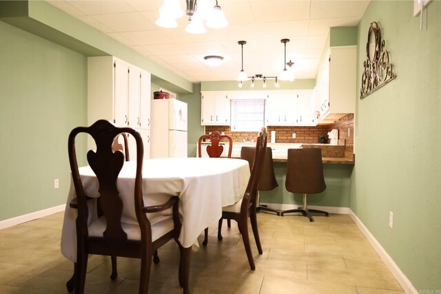 tiled dining area featuring a notable chandelier