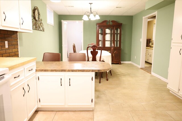 kitchen featuring an inviting chandelier, decorative light fixtures, and white cabinets