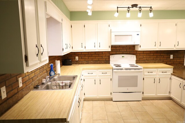 kitchen with white appliances, sink, decorative backsplash, and white cabinets