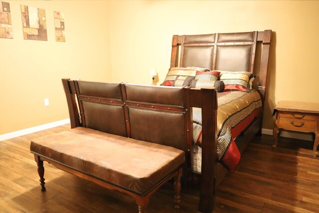 bedroom with dark hardwood / wood-style floors