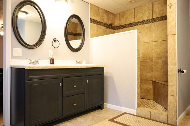 bathroom with vanity, tile patterned flooring, and a tile shower