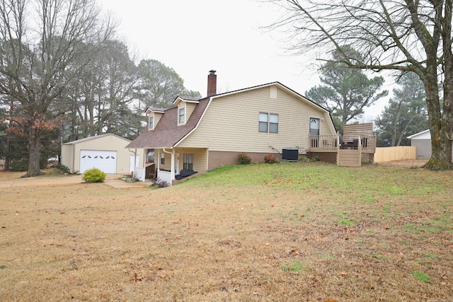 back of house with an outbuilding, central AC unit, a garage, and a yard