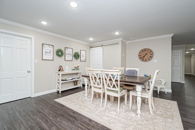 dining area featuring dark hardwood / wood-style floors, ornamental molding, and a barn door