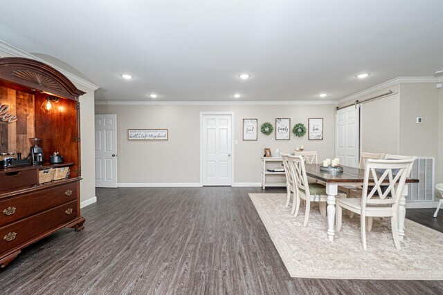 dining area with dark hardwood / wood-style floors, a barn door, and crown molding