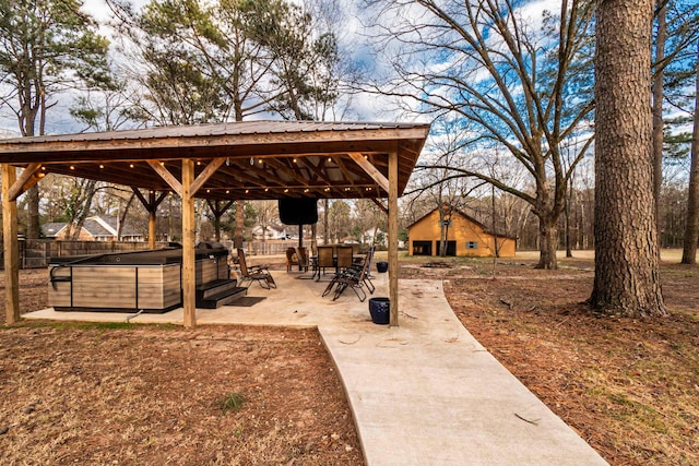 view of community with a gazebo, a hot tub, and a patio