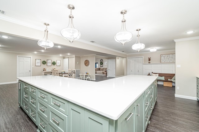 kitchen with ornamental molding, a kitchen island, green cabinets, and dark hardwood / wood-style flooring