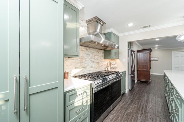 kitchen featuring crown molding, appliances with stainless steel finishes, backsplash, ventilation hood, and green cabinetry