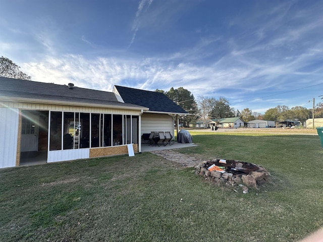 view of yard with an outdoor fire pit and a sunroom