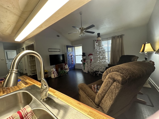 living room featuring ceiling fan, sink, dark hardwood / wood-style floors, and vaulted ceiling