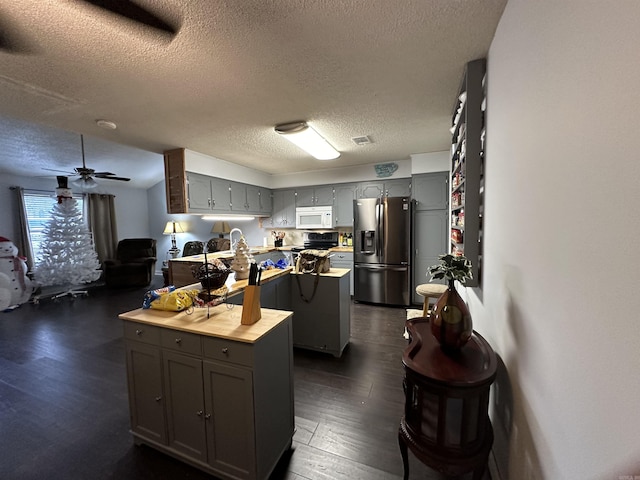 kitchen with dark wood-type flooring, a center island, gray cabinets, ceiling fan, and stainless steel appliances