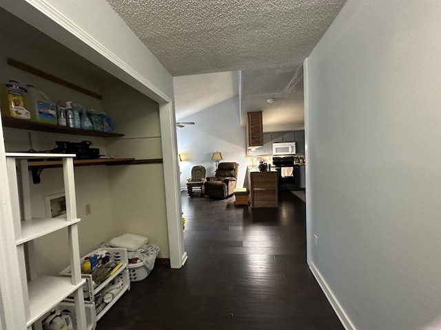 corridor with dark hardwood / wood-style flooring and a textured ceiling