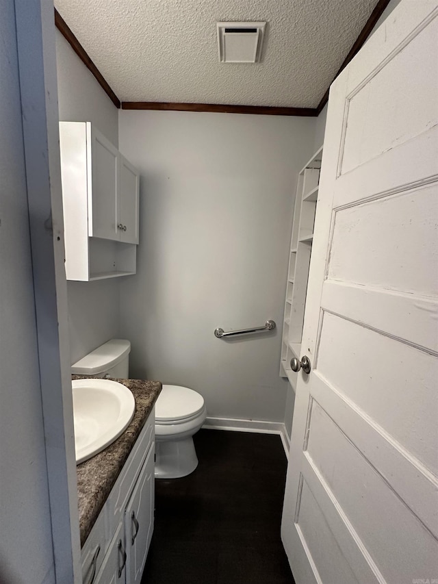 bathroom featuring ornamental molding, vanity, toilet, and a textured ceiling