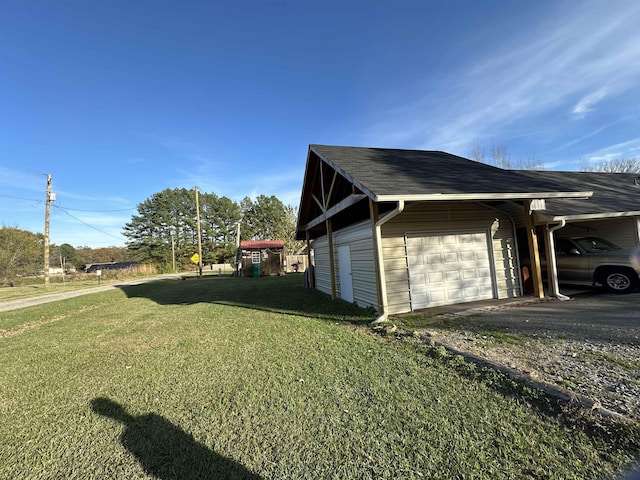 view of side of home featuring a garage, an outbuilding, a carport, and a lawn