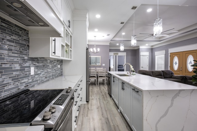 kitchen featuring stainless steel appliances, white cabinetry, sink, and decorative light fixtures