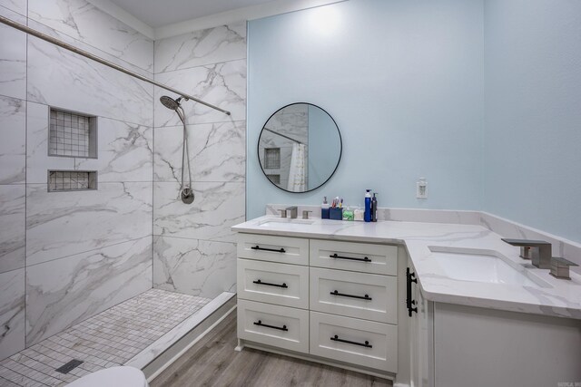 bathroom with vanity, tiled shower, and hardwood / wood-style floors