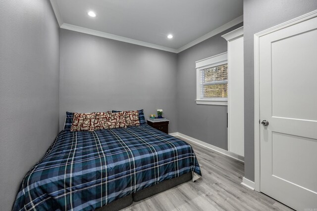 bedroom with hardwood / wood-style flooring and crown molding