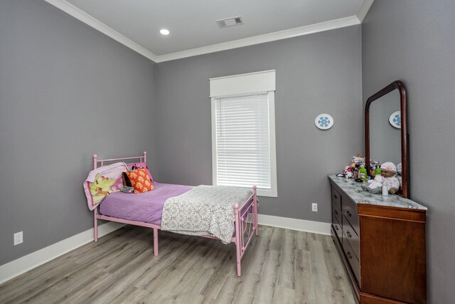 bedroom with crown molding and light wood-type flooring