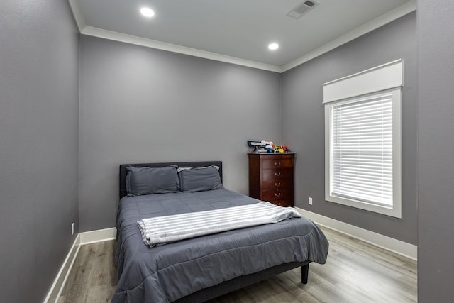 bedroom featuring crown molding and hardwood / wood-style flooring