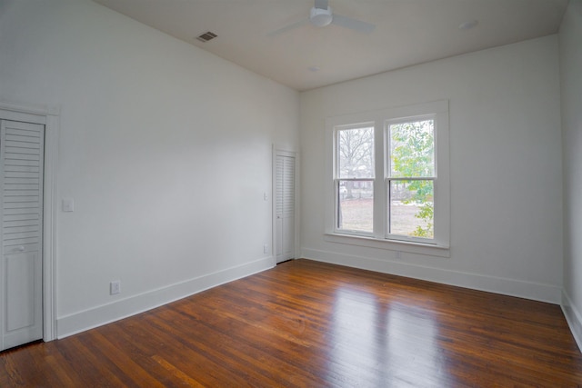 empty room with dark hardwood / wood-style flooring and ceiling fan