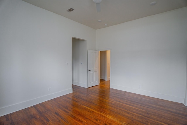 empty room with dark hardwood / wood-style flooring and ceiling fan