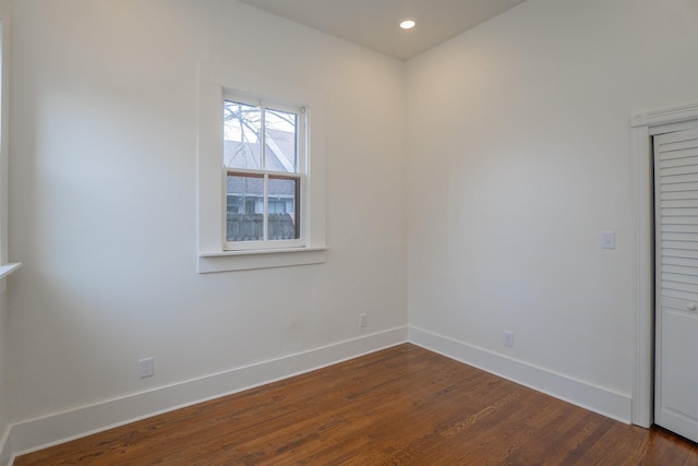 unfurnished room with dark hardwood / wood-style flooring