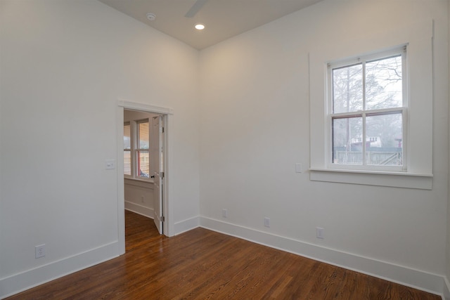 empty room with plenty of natural light, dark hardwood / wood-style floors, and ceiling fan