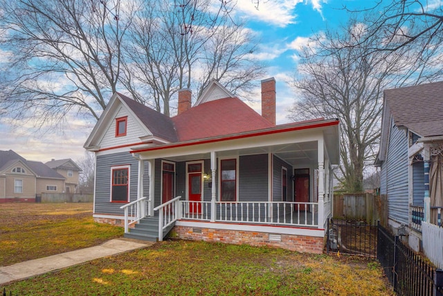 view of front of house featuring covered porch and a front lawn