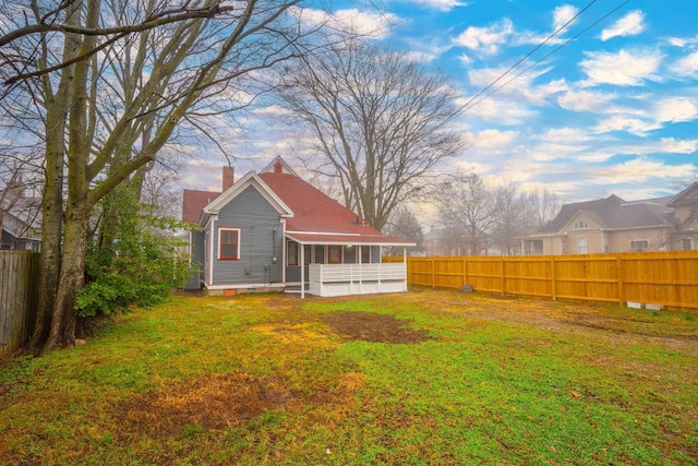 rear view of house with a lawn and a sunroom