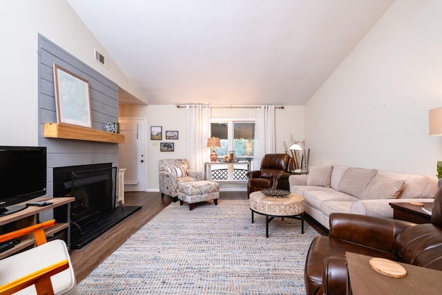 living room featuring vaulted ceiling and dark hardwood / wood-style floors