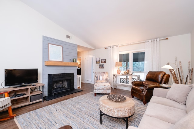 living room with hardwood / wood-style floors, a fireplace, and high vaulted ceiling