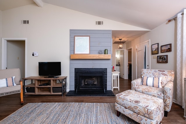 living room featuring vaulted ceiling with beams and dark wood-type flooring