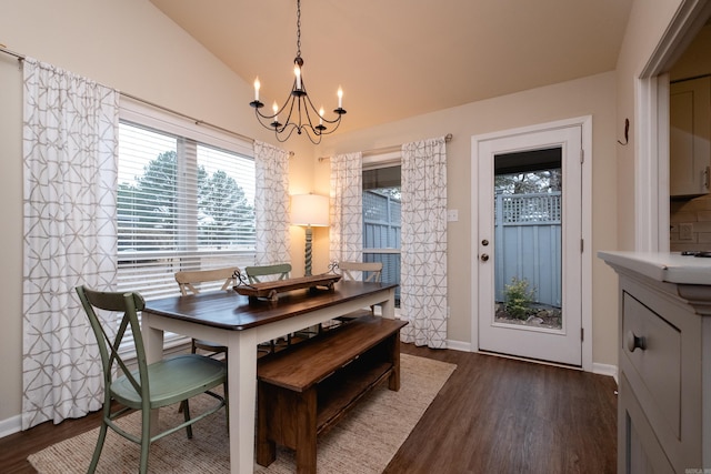 dining space featuring lofted ceiling, dark hardwood / wood-style flooring, and an inviting chandelier