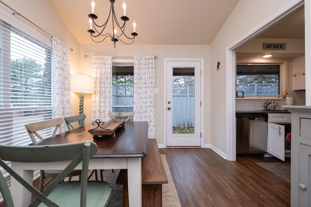 dining space with sink, dark hardwood / wood-style flooring, vaulted ceiling, and a notable chandelier