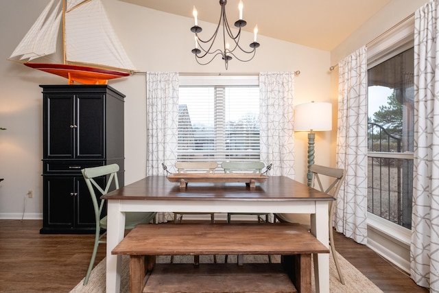 dining room with vaulted ceiling, dark hardwood / wood-style floors, and a notable chandelier