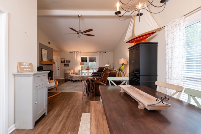 dining area with beamed ceiling, wood-type flooring, ceiling fan with notable chandelier, and high vaulted ceiling