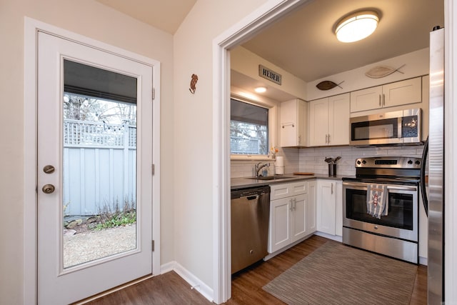 kitchen with white cabinetry, appliances with stainless steel finishes, sink, and dark hardwood / wood-style floors