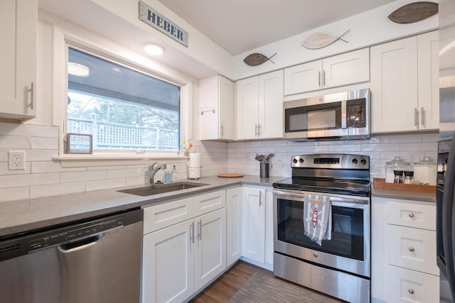 kitchen featuring white cabinetry, appliances with stainless steel finishes, sink, and decorative backsplash