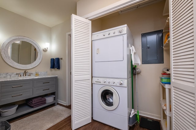 clothes washing area with dark hardwood / wood-style floors, stacked washing maching and dryer, electric panel, and sink