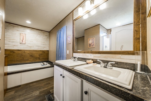 bathroom featuring vanity, hardwood / wood-style floors, plus walk in shower, and a textured ceiling