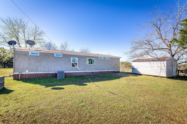 rear view of house featuring cooling unit, a yard, and a shed