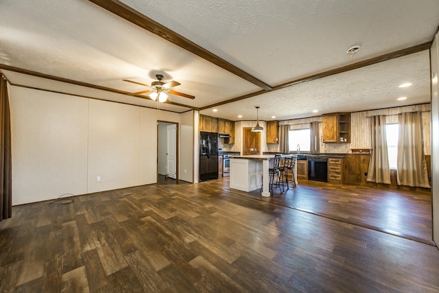 kitchen with pendant lighting, a breakfast bar area, dark hardwood / wood-style flooring, a center island, and black appliances