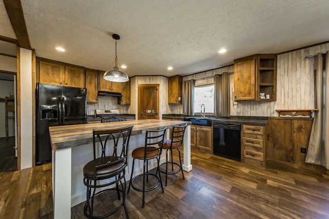 kitchen with sink, a center island, hanging light fixtures, dark hardwood / wood-style floors, and black appliances