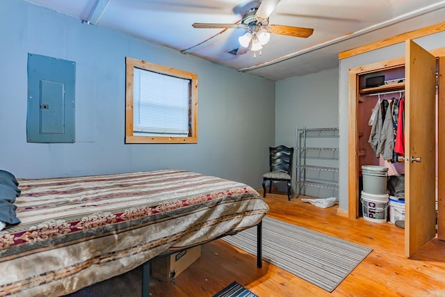 bedroom featuring hardwood / wood-style floors, electric panel, and ceiling fan