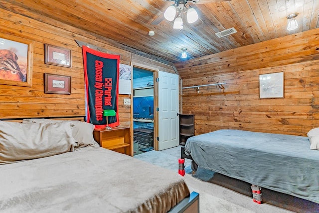 bedroom with wooden ceiling, wood walls, ceiling fan, and carpet flooring