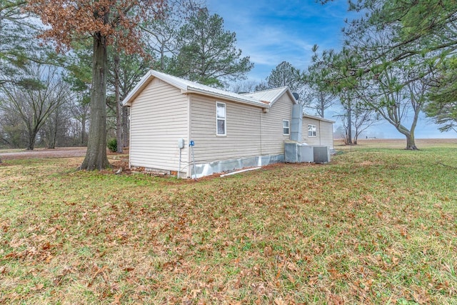 view of side of home featuring a lawn and central air condition unit